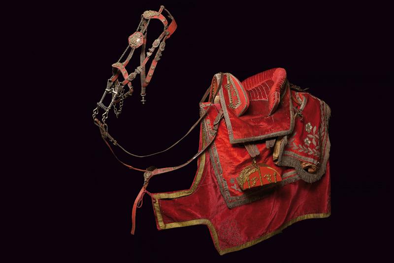 Importante sella in velluto rosso completa di staffe, sottosella e briglia con morso